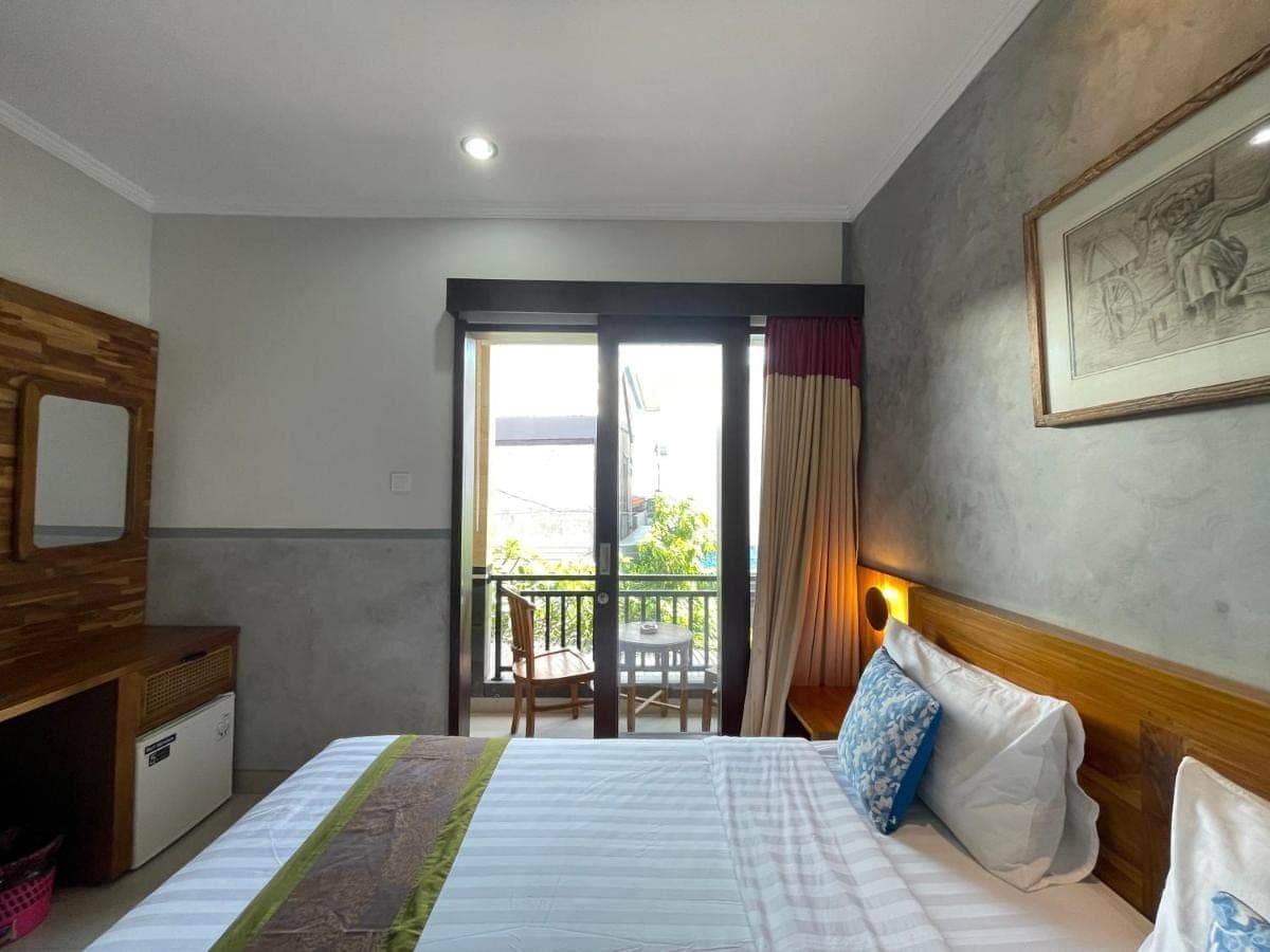 a hotel room with a bed and a balcony at Kubu Indah Homestay Sanur in Sanur