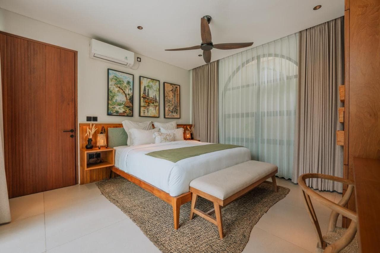 a bedroom with a bed and a chair in it at Adaya Boutique Villas in Uluwatu