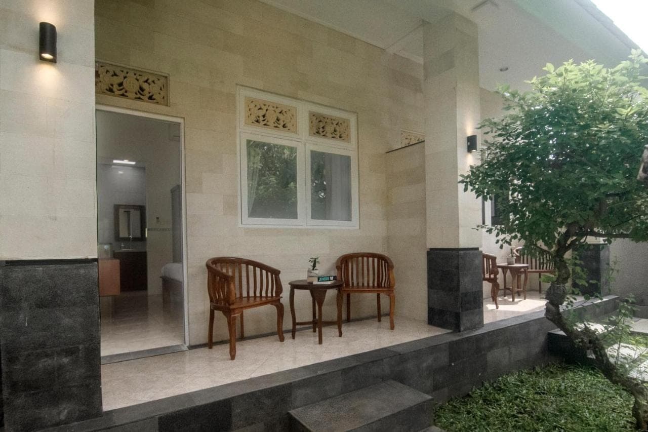 a patio with two chairs and a table in a house at The Cozy Haven Sanur in Sanur
