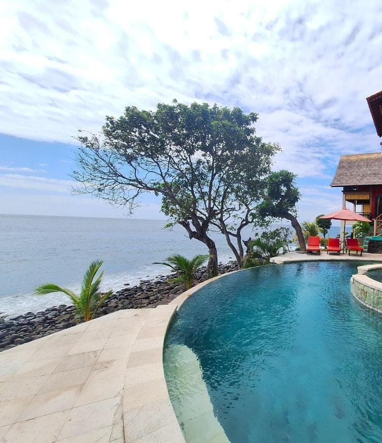 a swimming pool with a view of the ocean at Amed Santorini Villa in Amed