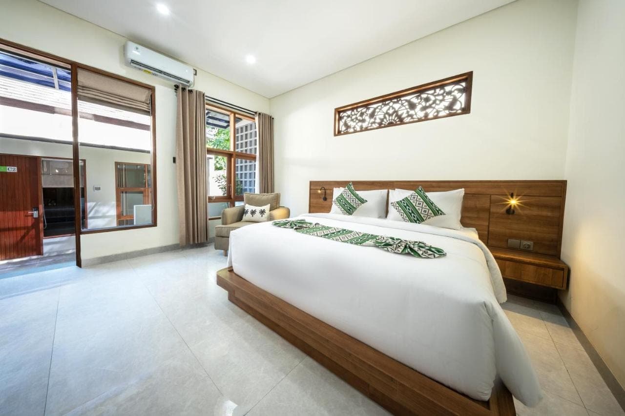 a bedroom with a large bed in a room at Sadira Guest House Seminyak in Seminyak