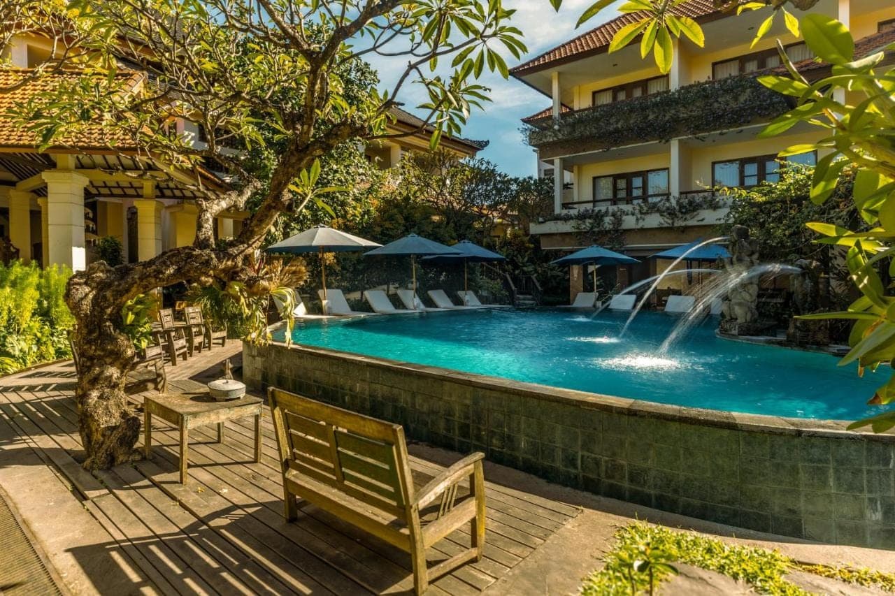 a swimming pool in front of a building with a resort at Sri Phala Resort & Villa in Sanur