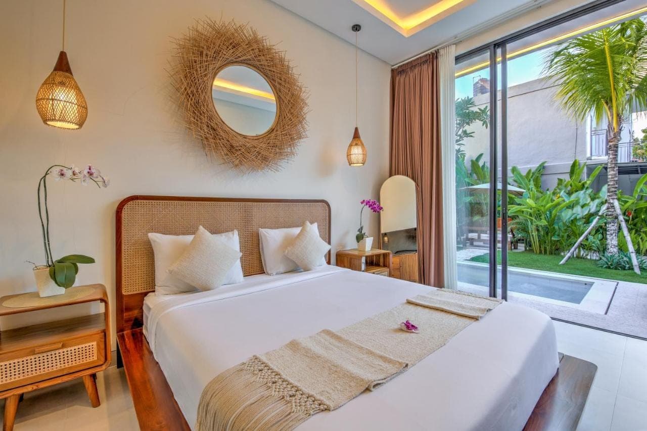 a bedroom with a bed and a large window at Soul Garden Villa Nusa dua in Nusa Dua