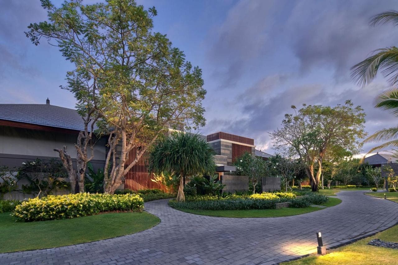 a walkway in front of a building with trees and flowers at Marriott's Bali Nusa Dua Terrace in Nusa Dua