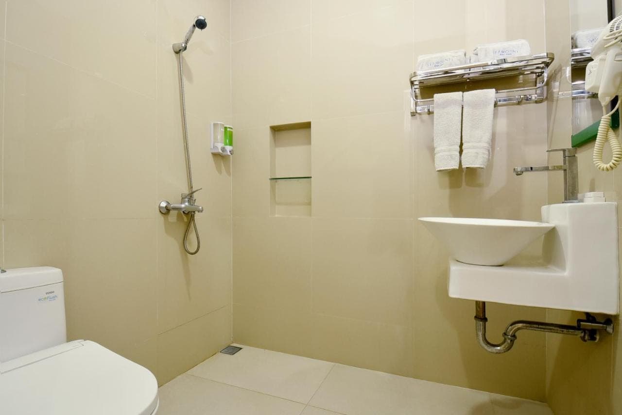 a bathroom with a white toilet and a sink at Seamount Hotel Amed in Amed