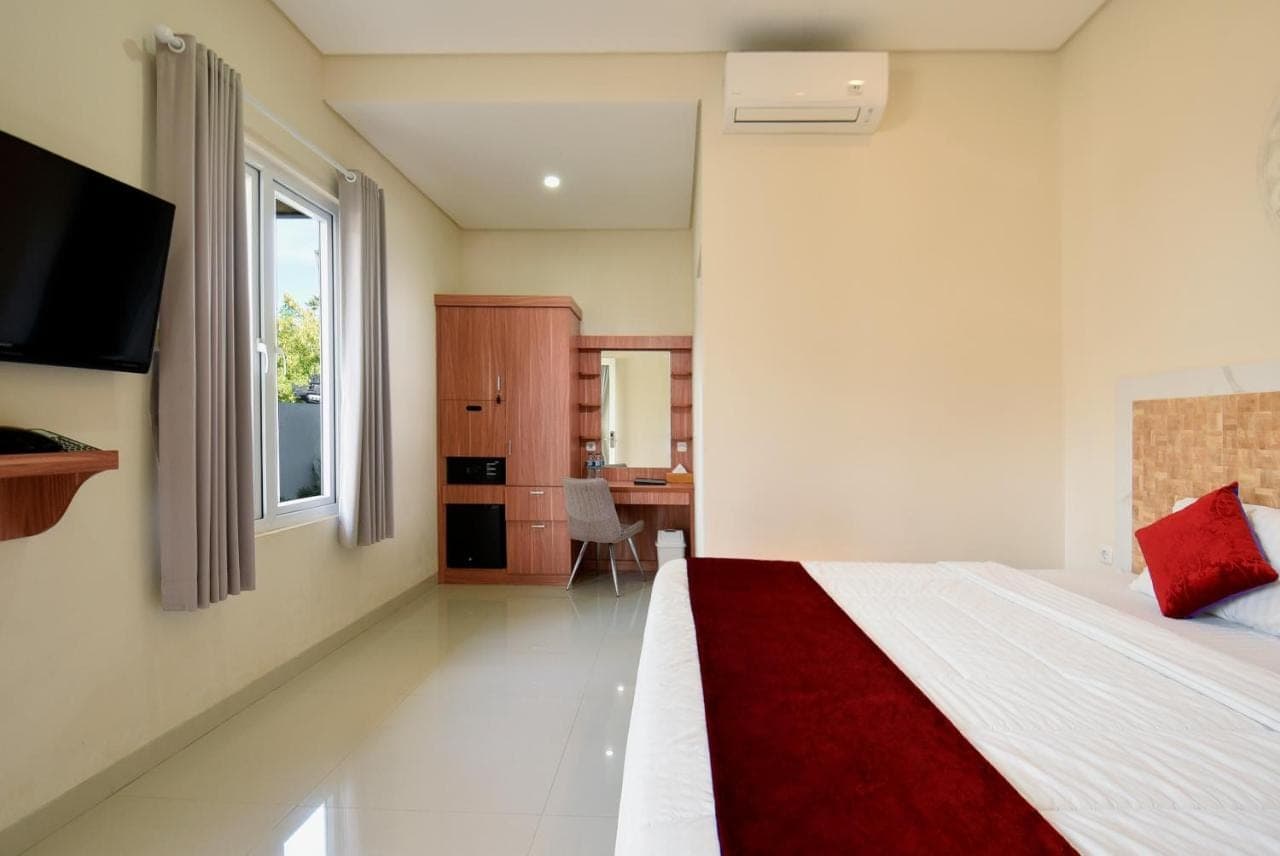 a bedroom with a bed and a desk and a window at Seamount Hotel Amed in Amed