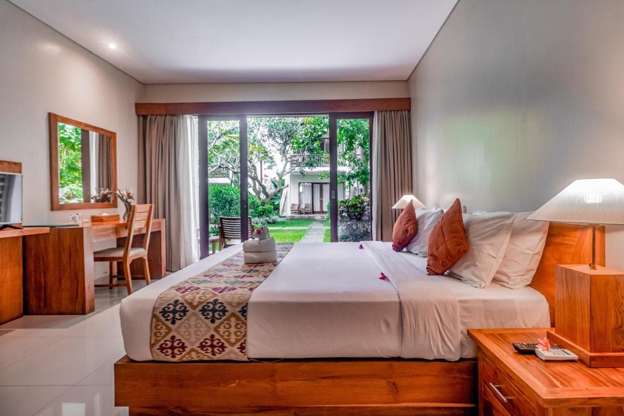 a bedroom with a large bed and a dining room at Pertiwi Bisma Ubud in Ubud