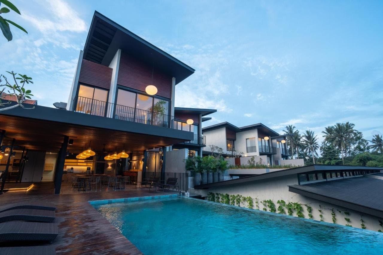 a house with a swimming pool in front of a house at Umahan Ubud in Ubud
