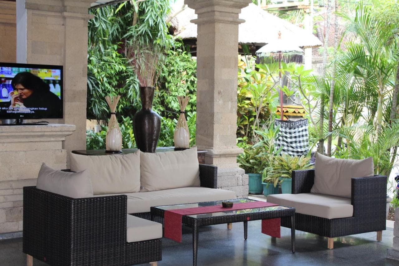 a living room with a couch and chairs and a tv at Bali Agung Village in Seminyak