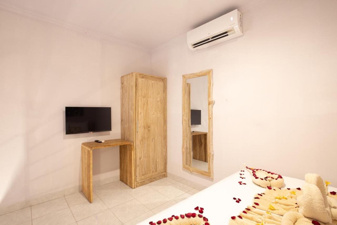 a bedroom with a bed and a tv and a mirror at Maisaba Seminyak Loft & Villas in Seminyak