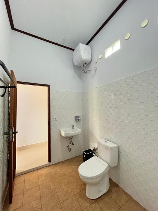 a bathroom with a toilet and a sink at Krisna Double House in Sidemen
