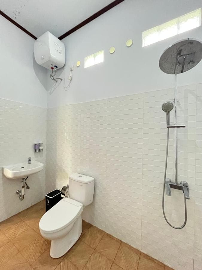 a bathroom with a toilet and a sink and a shower at Krisna Double House in Sidemen