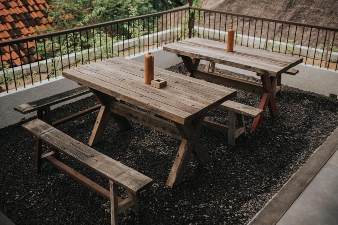 two picnic tables and benches with candles on them at Sare Homestay and Artspace Sanur in Sanur
