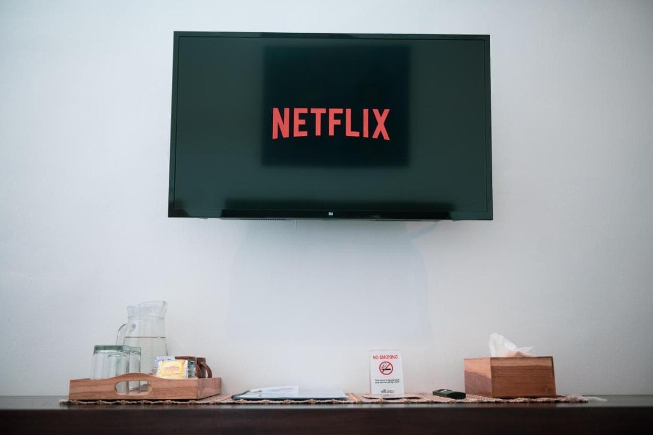 a television with the words netflix on a wall at Sare Homestay and Artspace Sanur in Sanur