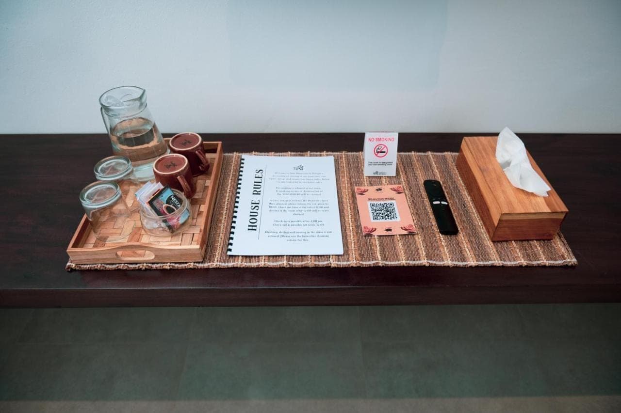 a table with a tray with a book and other items at Sare Homestay and Artspace Sanur in Sanur