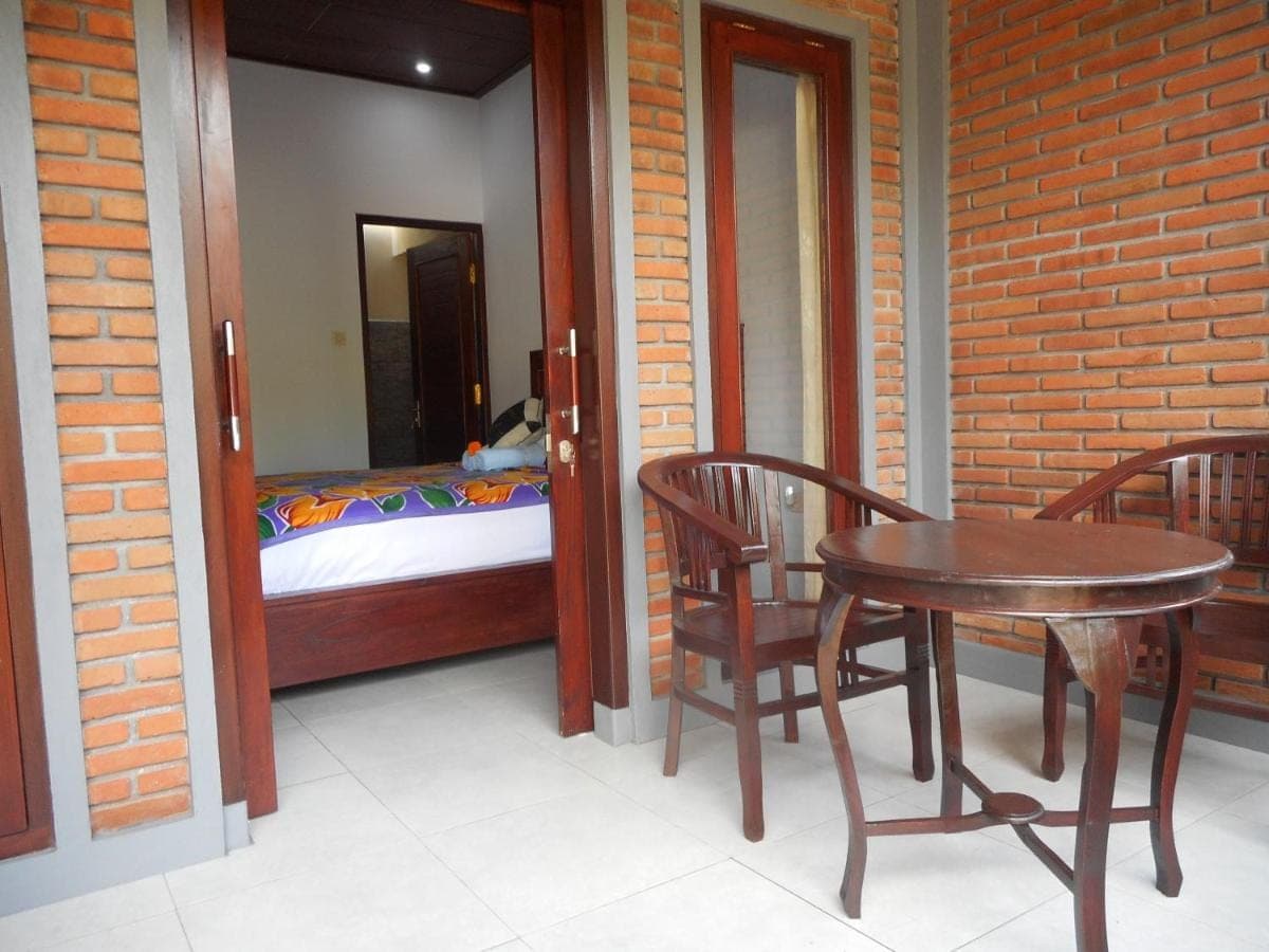 a room with a table and chairs and a bed at Pondok Indah Homestay in Sidemen