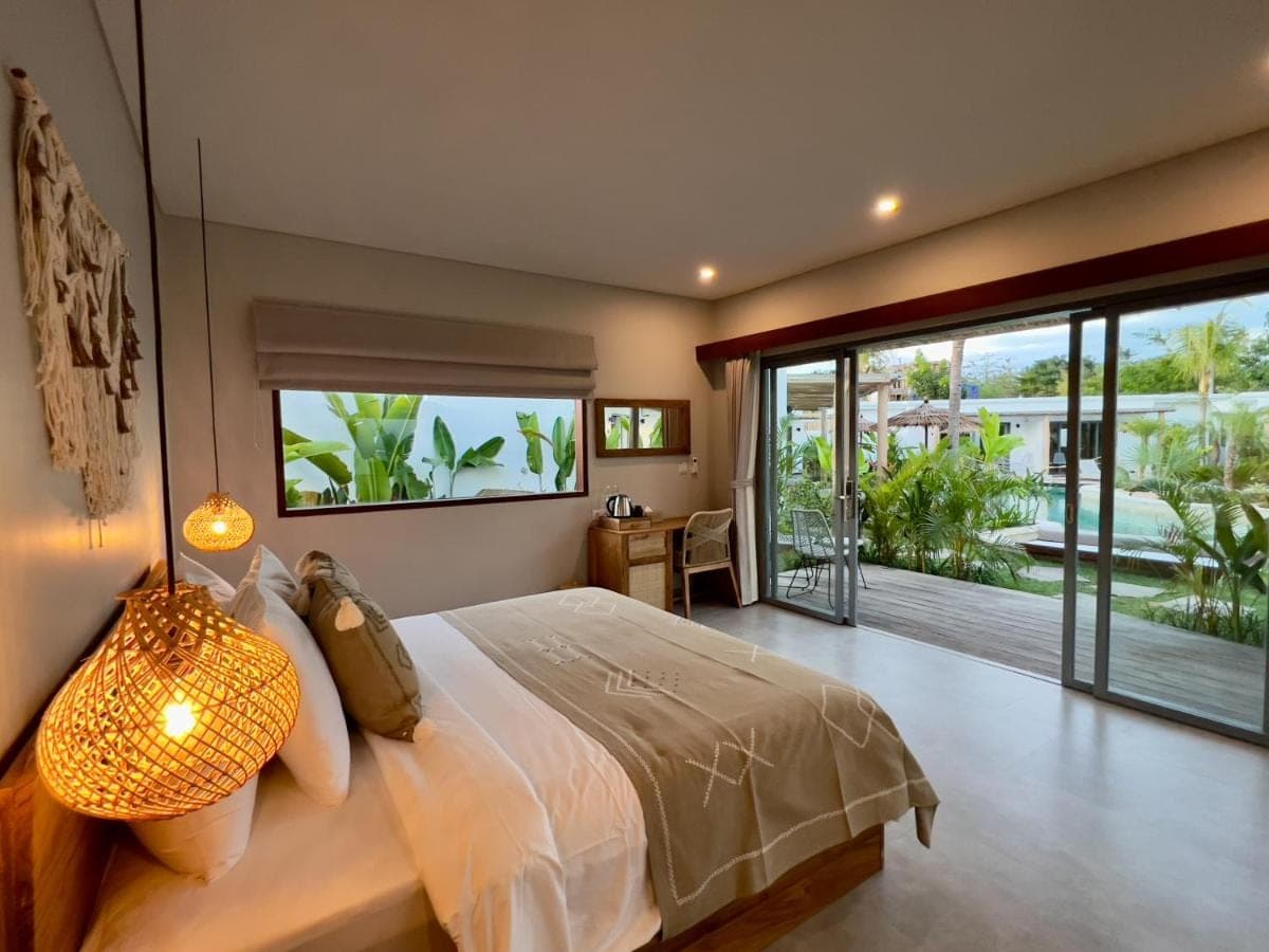 a bedroom with a large bed and a large window at Kalia Bingin - Adult only in Uluwatu