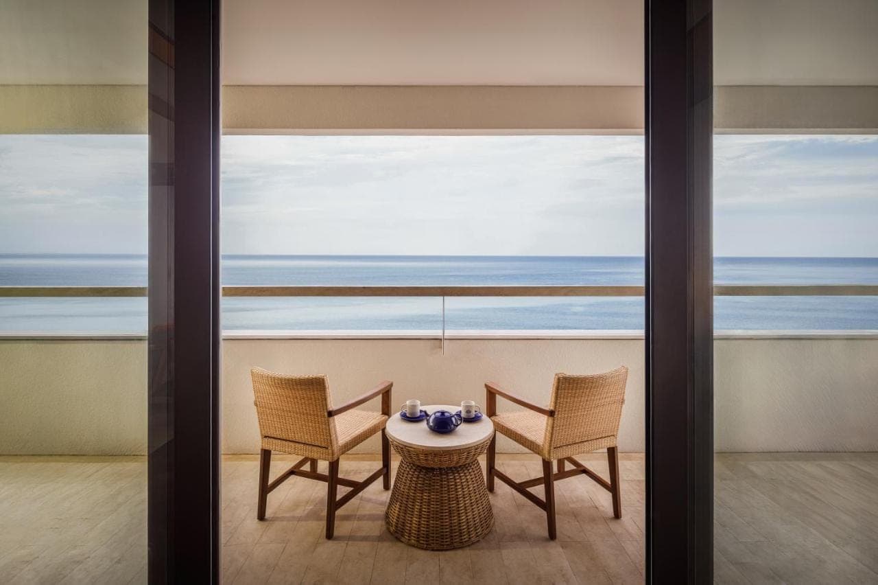 a table and chairs in a room with a view of the ocean at Bali Beach Hotel in Sanur