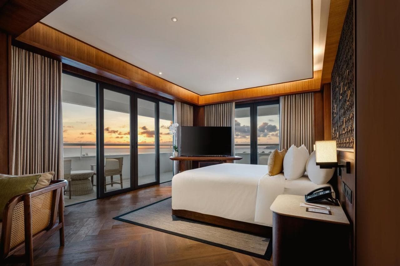 a bedroom with a bed and a view of the ocean at Bali Beach Hotel in Sanur