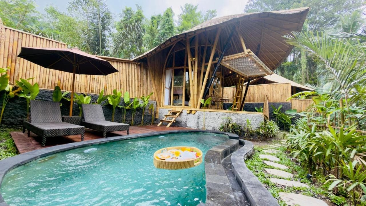 a house with a swimming pool in a yard at Phoenix Bamboo House by Ecobreeze in Sidemen