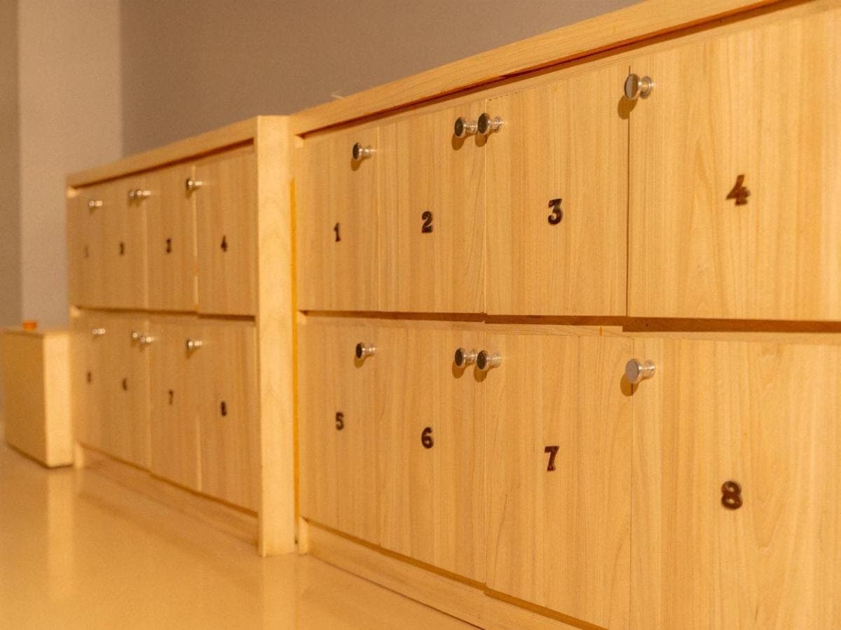 a row of wooden cabinets with numbers on them at Kuta Cube Hostel in Kuta