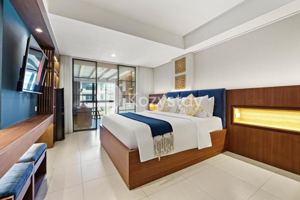 a bedroom with a large bed and a television at Vantara by Kozystay - Nusa Dua in Nusa Dua