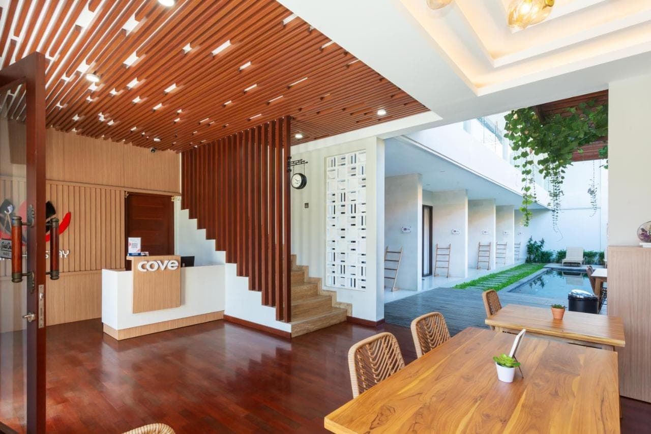 a dining room with a table and a pool at Cove Ransha Stay in Sanur