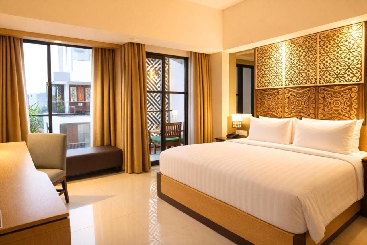 a hotel room with a bed and a window at Metland Seva Seminyak - Formerly Horison Ultima Seminyak in Seminyak