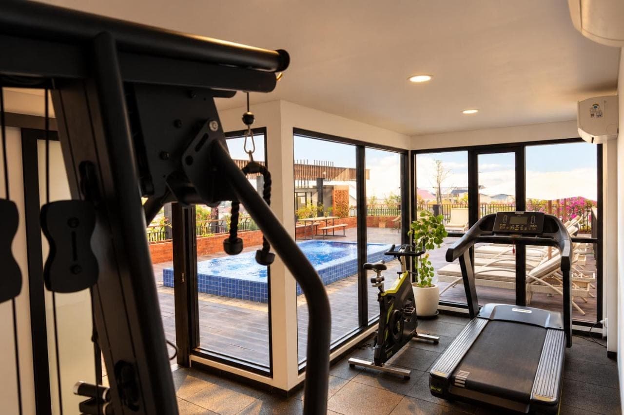 a gym with a view of a swimming pool at Metland Seva Seminyak - Formerly Horison Ultima Seminyak in Seminyak