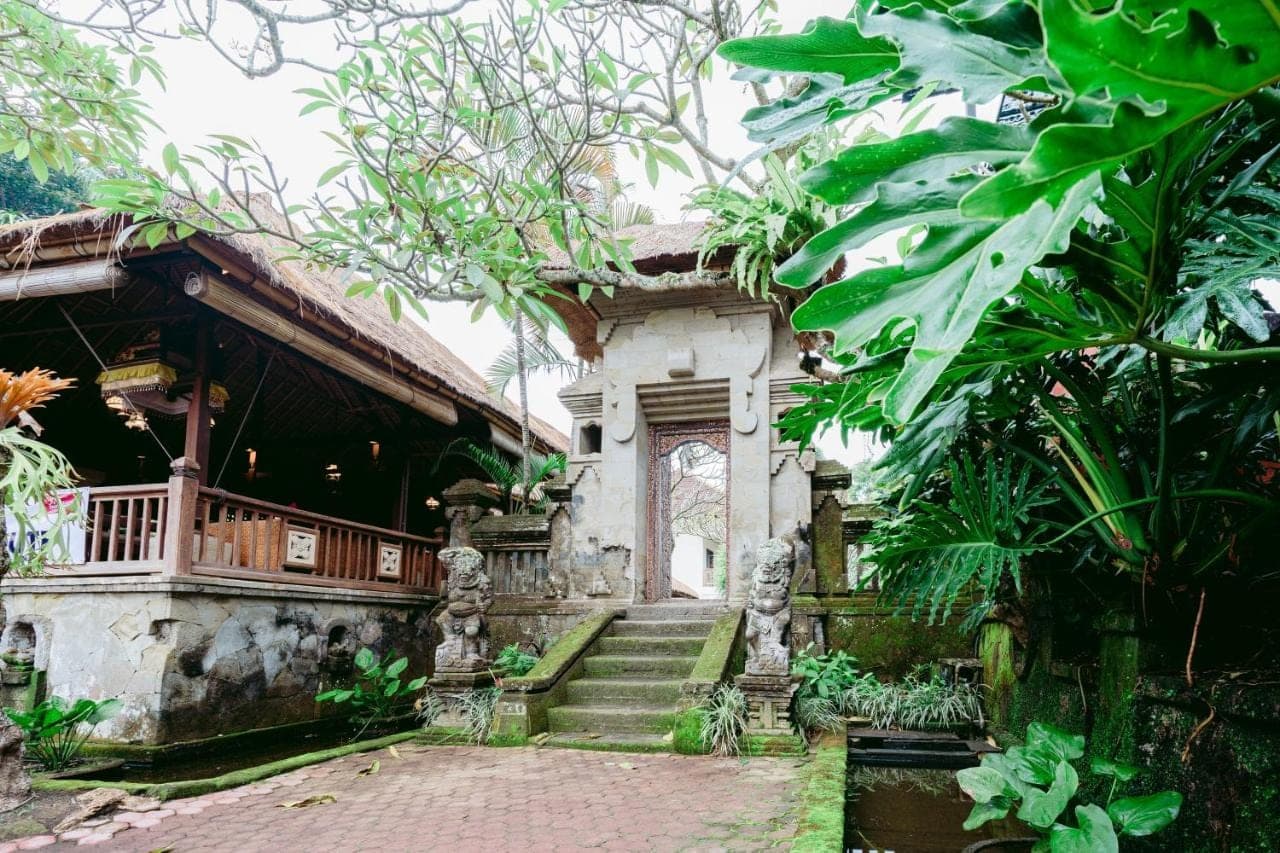 a building with a porch and stairs in a garden at Pertiwi Resort & Spa in Ubud