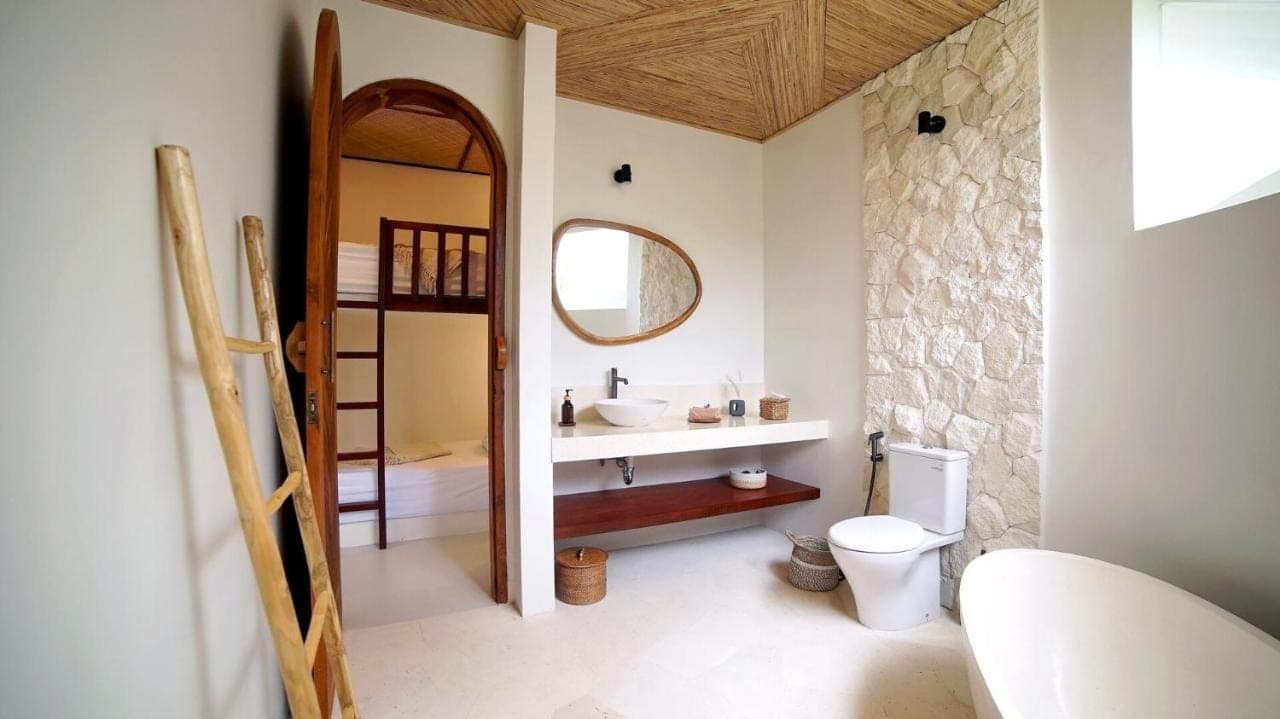 a bathroom with a sink and a toilet and a mirror at Villa Naga\u00efa - Private Pool, Rooftop & Agung Views in Amed