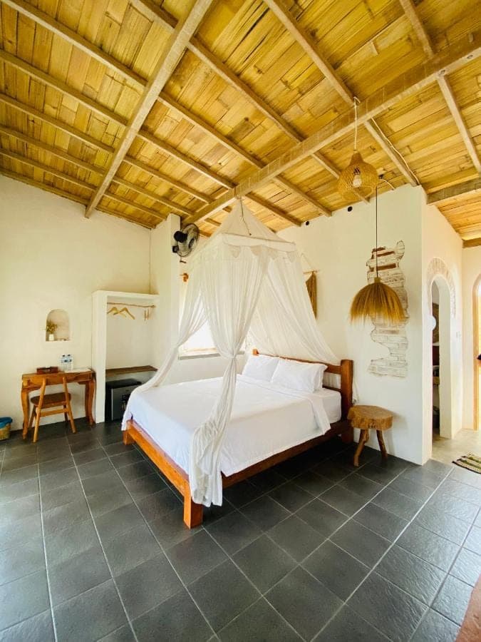 a bedroom with a bed with a mosquito net at Cozy bliss homestay sidemen in Sidemen