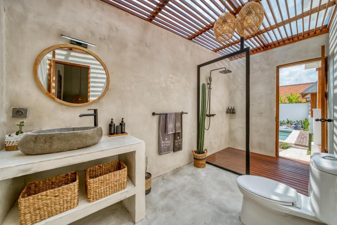 a bathroom with a sink and a toilet and a mirror at Noho Stay Bali in Uluwatu