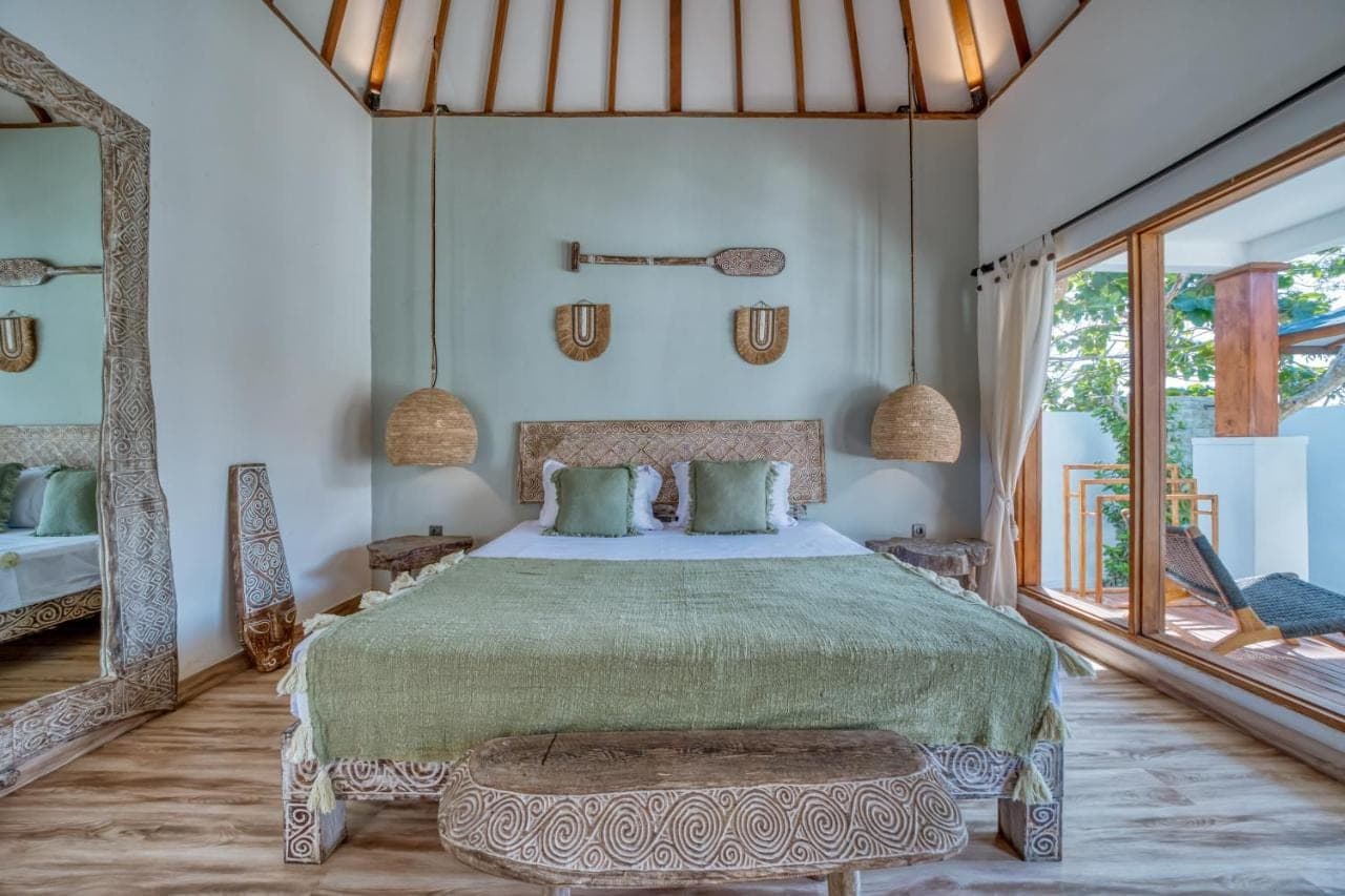 a bedroom with a large bed and a large window at Noho Stay Bali in Uluwatu