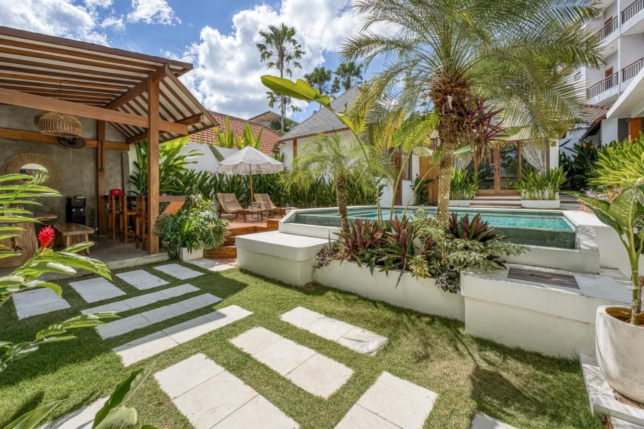 a backyard with a swimming pool and a house at Noho Stay Bali in Uluwatu