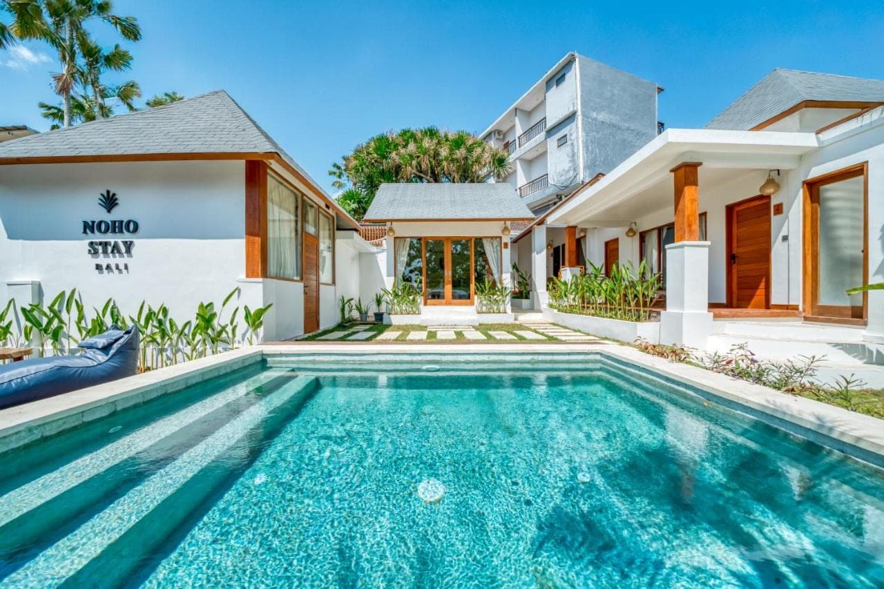 a swimming pool in front of a house at Noho Stay Bali in Uluwatu
