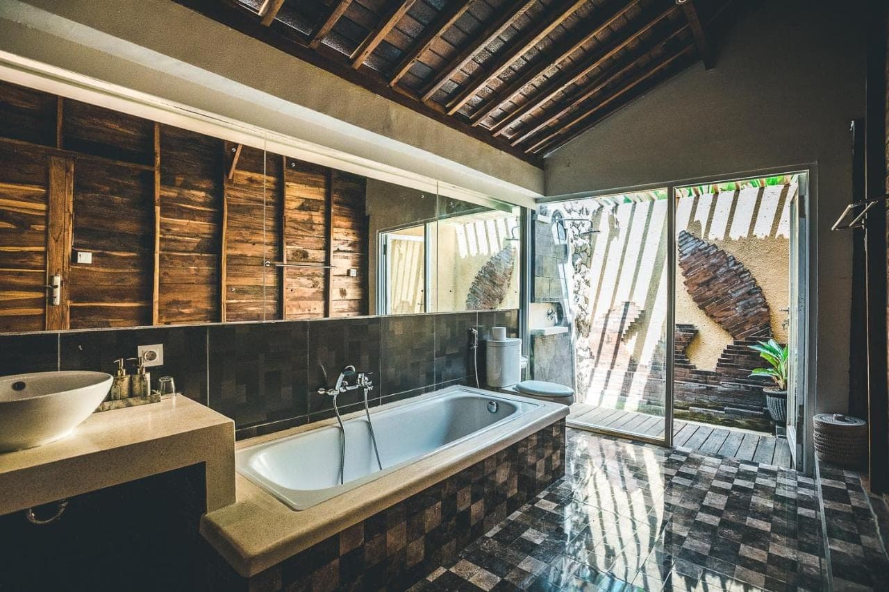 a bathroom with a tub and a sink at Ocho Bali Surf Camp in Uluwatu