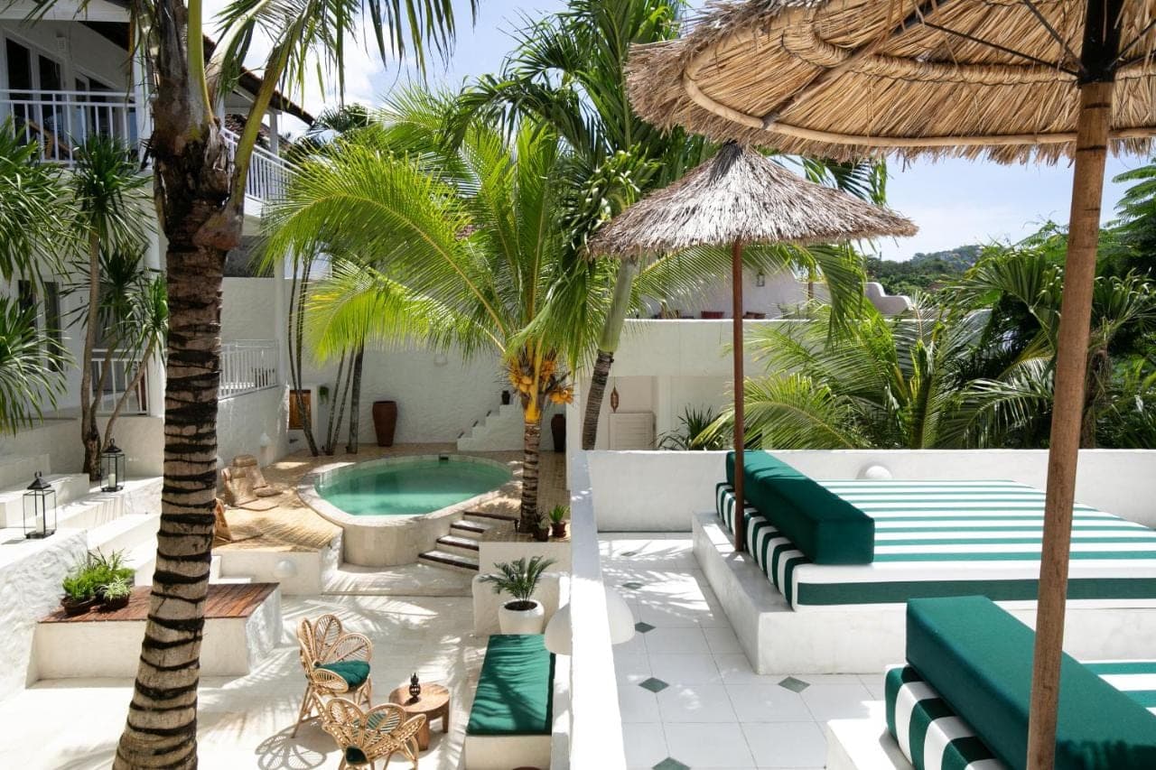 a resort with a pool and chairs and an umbrella at Segredo Uluwatu in Uluwatu