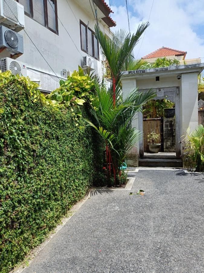 a house with a gate and a driveway at Ngetis Home Stay in Sanur