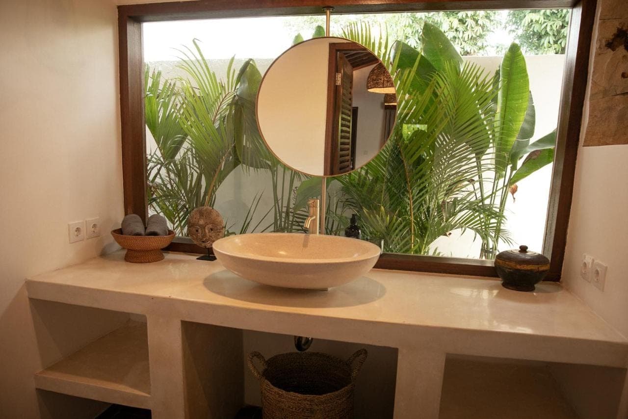 a bathroom with a sink and a mirror on a counter at La Kreyiol in Uluwatu