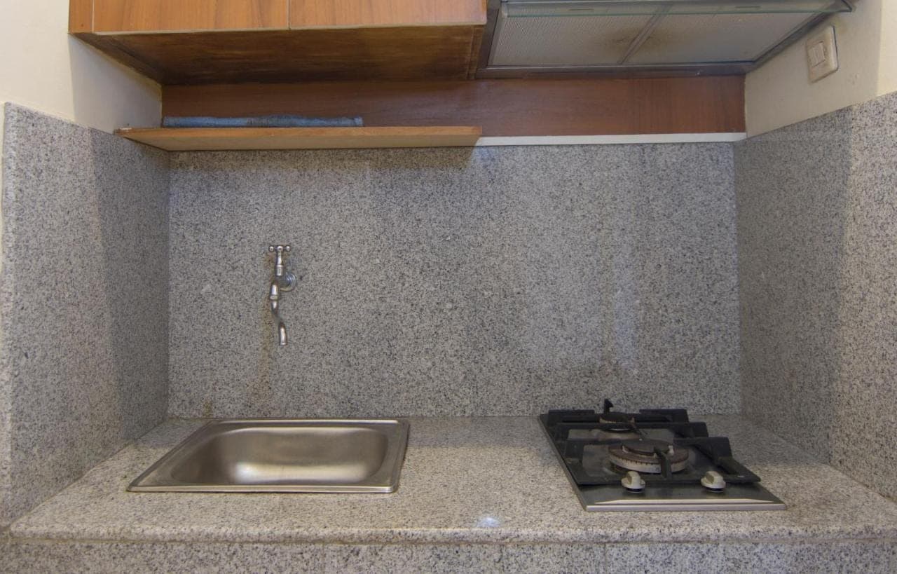 a kitchen counter top with a sink and a sink at Pondok Nuri Homestay in Sanur