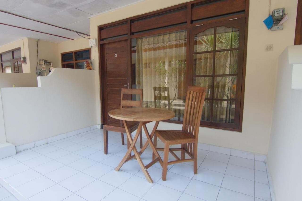 a table and chairs in a room with a window at Pondok Nuri Homestay in Sanur