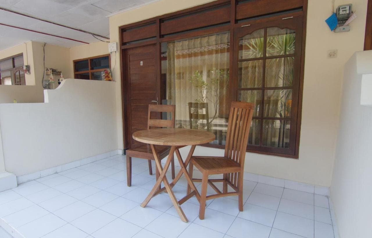 a table and chairs in a room with a window at Pondok Nuri Homestay in Sanur