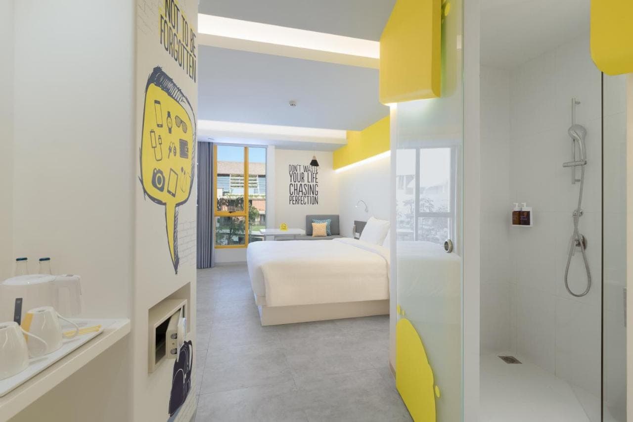 a hotel room with a bed and a bathroom at YELLO Hotel Kuta Beachwalk Bali in Kuta