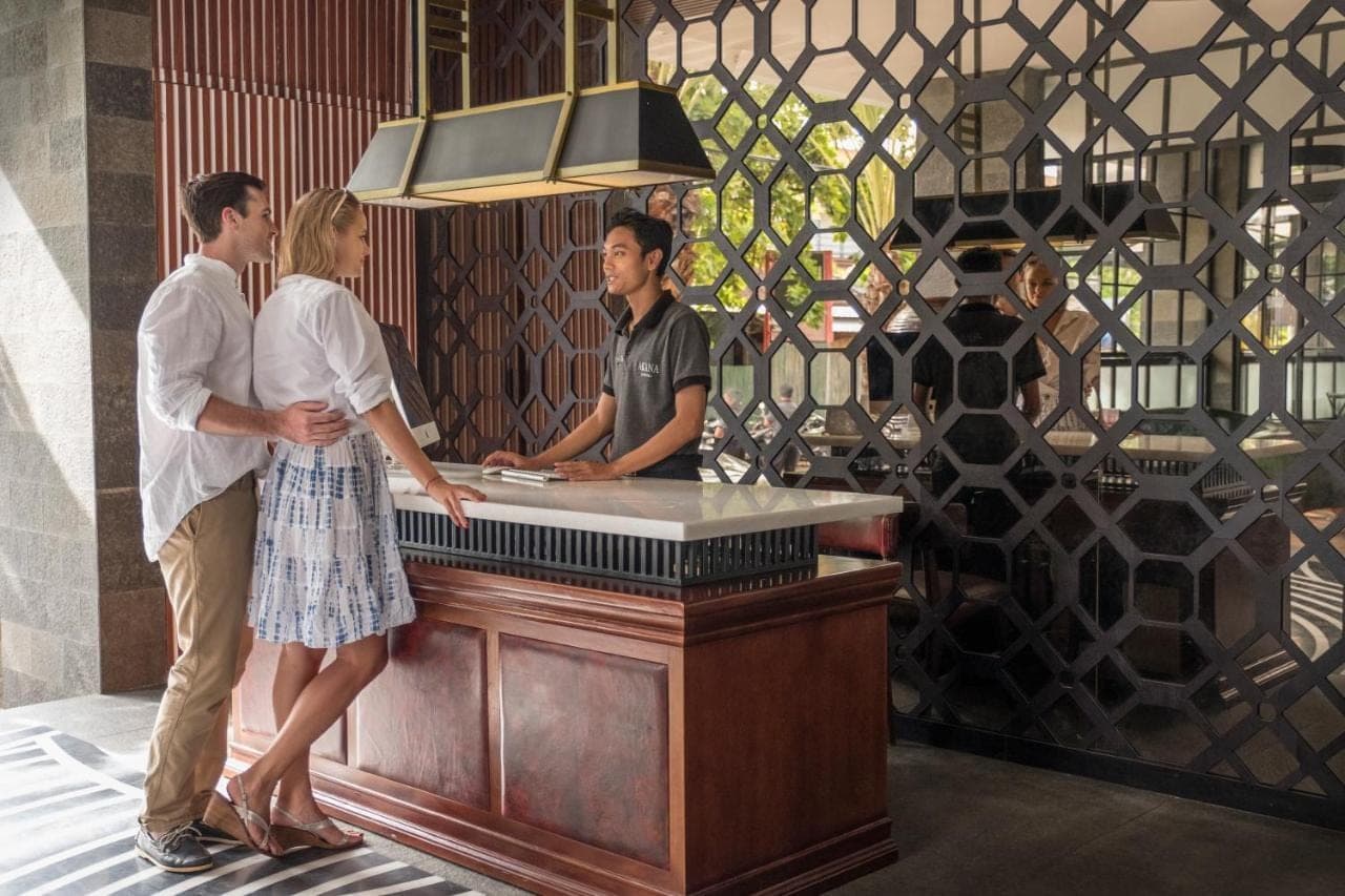 a group of three people standing at a bar at Akana Boutique Hotel in Sanur