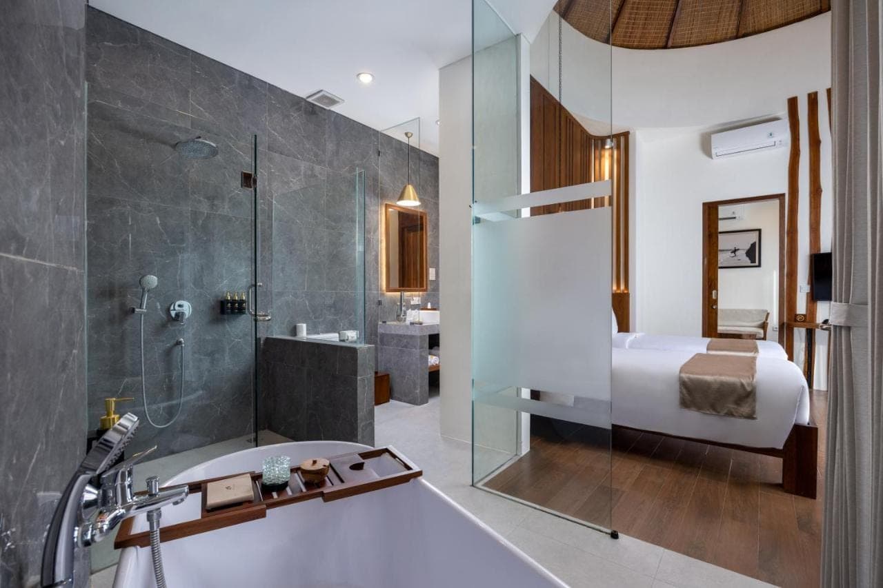 a bathroom with a shower and a tub and a sink at The Prime Canggu Bali by Kanaya Hospitality in Canggu