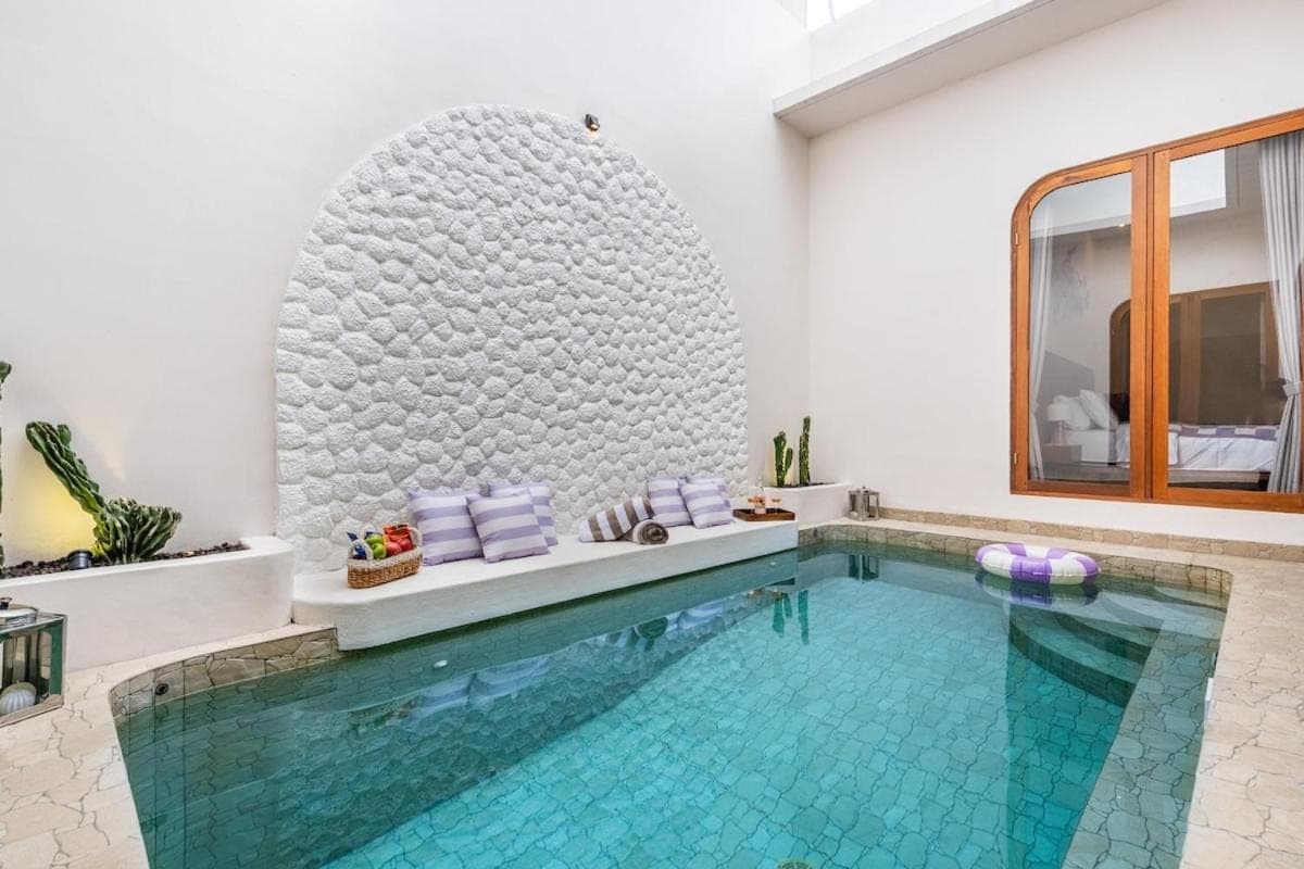 a swimming pool in a hotel room with a large swimming pool at Awaken your Mind and Body in the Solari Butterfly Villa in Sanur