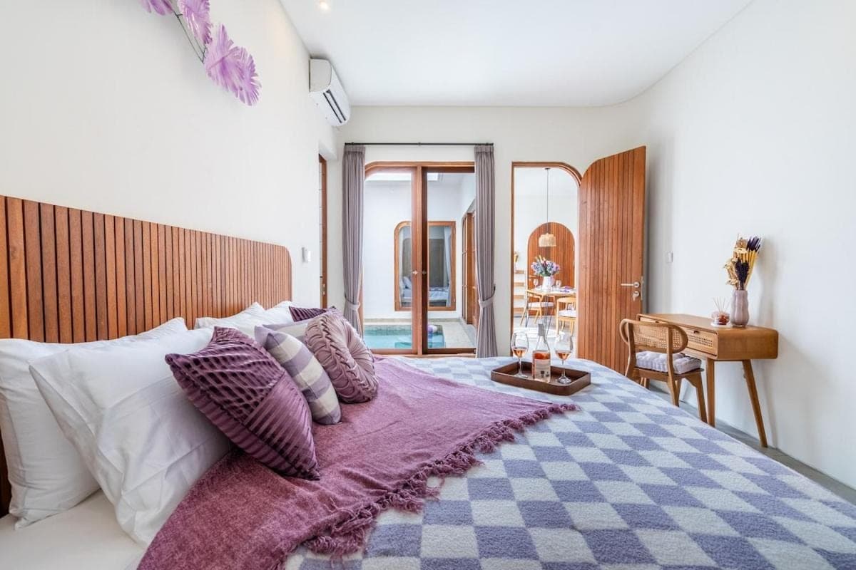 a bedroom with a large bed with a purple blanket at Awaken your Mind and Body in the Solari Butterfly Villa in Sanur
