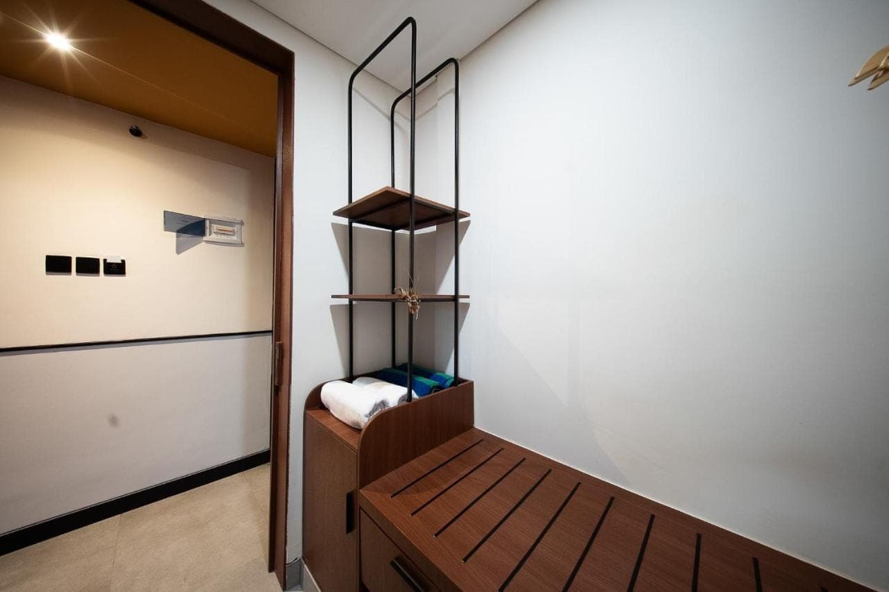 a bedroom with a wooden bench in a room at Padang Padang Inn in Uluwatu