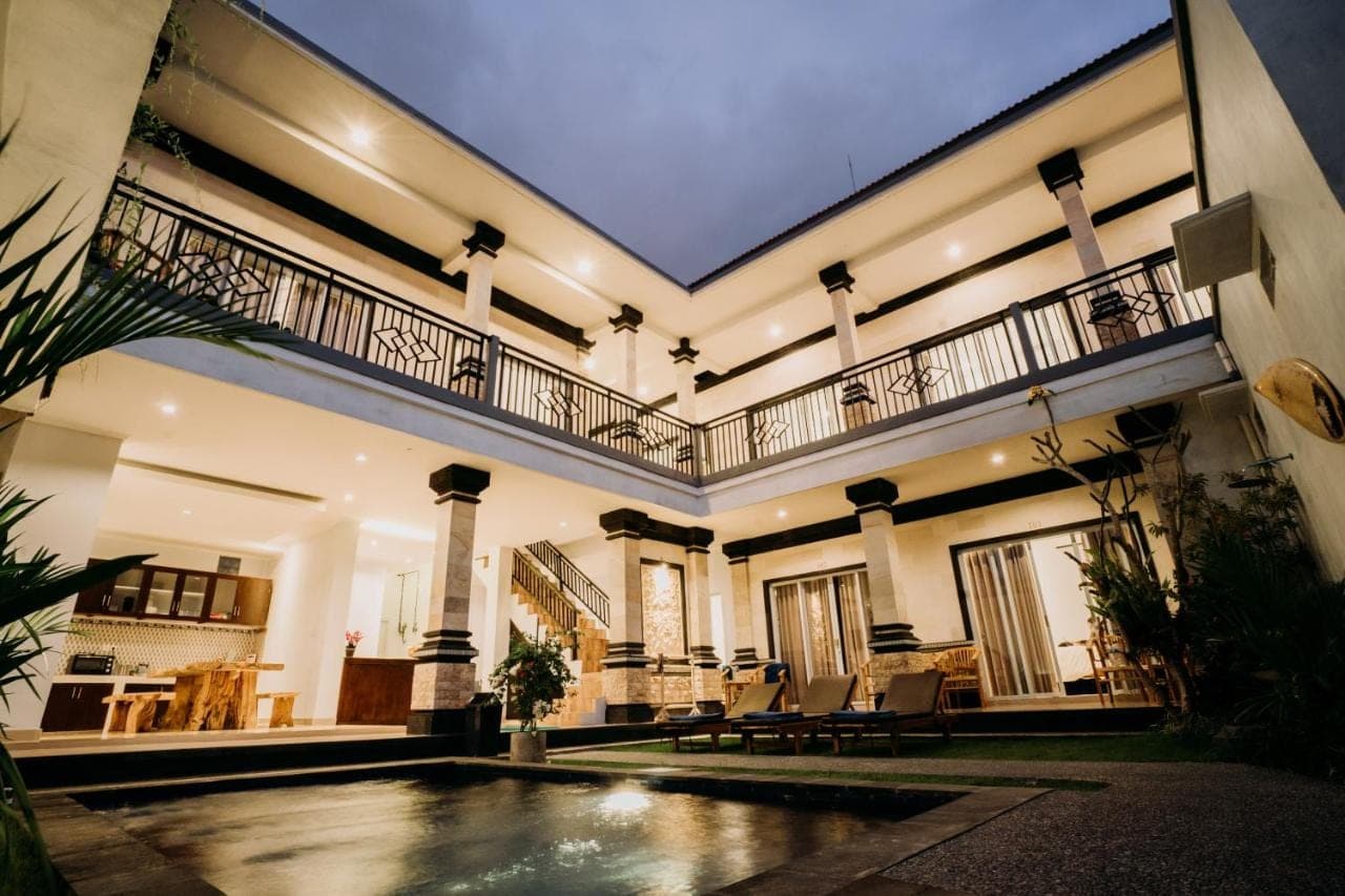 a large house with a swimming pool in the middle at Nova Guest House in Canggu
